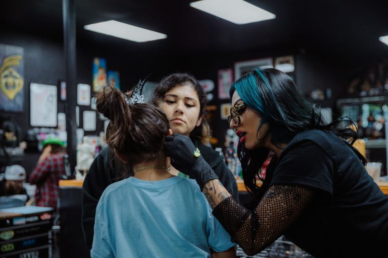 Piercer Birdie at Golden Child Tattoo & Piercing Shop performing an ear piercing on a young client during a session in Escondido, California.